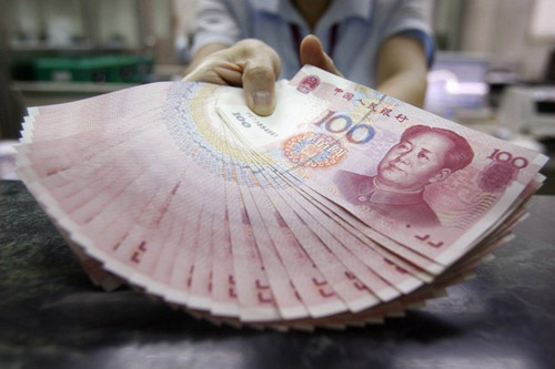 Staff member poses for the media with Chinese renminbi notes inside the Bank of Taiwan head office in Taipei