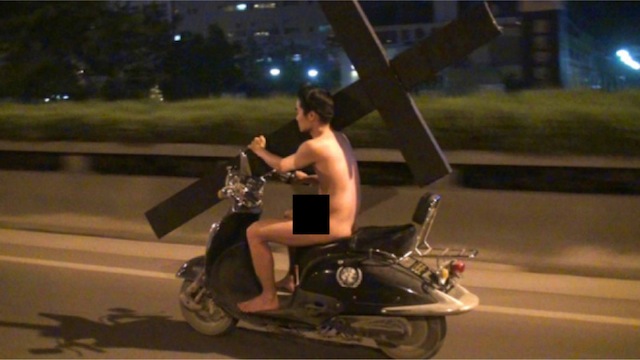 Фото: Голый китаец проехался по Пекину на скутере с огромным крестом